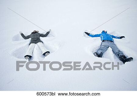 young couple lying in snow doing snow angels View Large Photo Image Stock Image - young couple lying in snow doing snow angels. Fotosearch