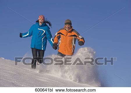 young couple running hand in hand through winter landscape View Large Photo Image Stock Image - young couple running hand in hand through winter landscape. Fotosearch