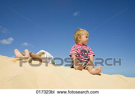 young girl and little brother lying and sitting on sand dune View Large Photo Image Stock Image - young girl and little brother lying and sitting on sand dune. Fotosearch