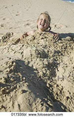 young girl buried under sand on beach View Large Photo Image Stock Image - young girl buried under sand on beach. Fotosearch