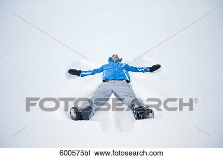 young man lying in snow doing snow angel View Large Photo Image Stock Image - young man lying in snow doing snow angel. Fotosearch