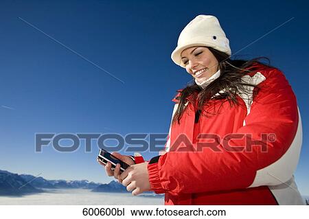 young woman in the mountains checking her mobile phone for text messages View Large Photo Image Stock Image - young woman in the mountains checking her mobile phone for text messages. Fotosearch