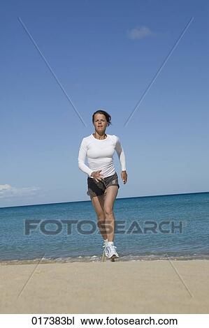 young woman jogging on sandy beach View Large Photo Image Stock Image - young woman jogging on sandy beach. Fotosearch