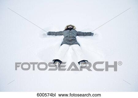young woman lying in snow doing snow angel View Large Photo Image Stock Image - young woman lying in snow doing snow angel. Fotosearch