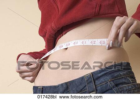 young woman measuring her waistline View Large Photo Image Stock Image - young woman measuring her waistline. Fotosearch