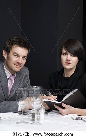 Stock Image - businessman and female colleague having business lunch. Fotosearch