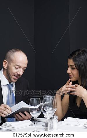 Stock Image - businessman and female colleague having business lunch. Fotosearch