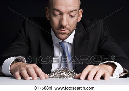 businessman looking at stack of paper clips View Large Photo Image Stock Image - businessman looking at stack of paper clips. Fotosearch
