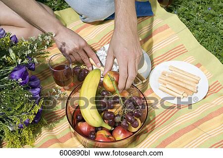 close-up of couple having picnic takng fruit from bowl View Large Photo Image Stock Image - close-up of couple having picnic takng fruit from bowl. Fotosearch