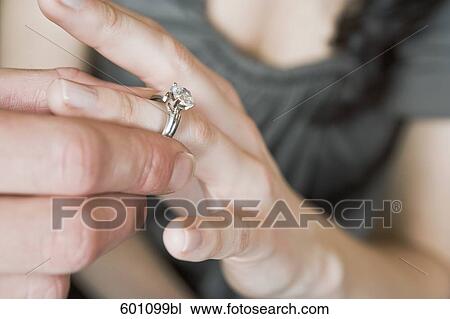 close-up of man putting finger on ring of woman View Large Photo Image Stock Image - close-up of man putting finger on ring of woman. Fotosearch