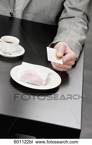 Stock Image - detail of man paying with credit card in restaurant. Fotosearch