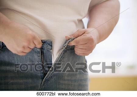detail of overweight woman trying to put on jeans trousers View Large Photo Image Stock Image - detail of overweight woman trying to put on jeans trousers. Fotosearch
