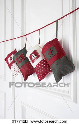 four sacks for christmas presents hanging on rope in front of door View Large Photo Image Stock Image - four sacks for christmas presents hanging on rope in front of door. Fotosearch