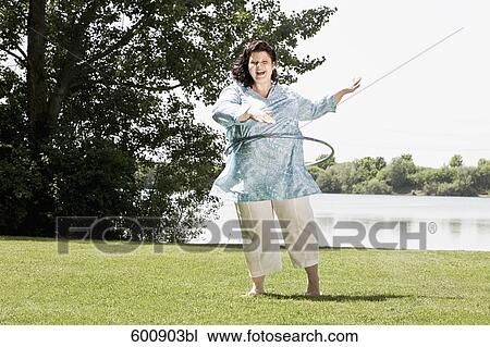 full body portrait of overweight woman doing hula hoop in the park View Large Photo Image Stock Image - full body portrait of overweight woman doing hula hoop in the park. Fotosearch
