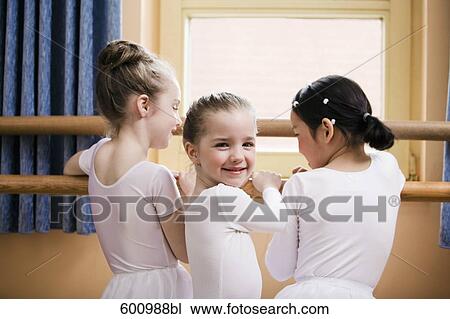 group of three young girls standing at ballet barre one looking at camera View Large Photo Image Stock Image - group of three young girls standing at ballet barre one looking at camera. Fotosearch
