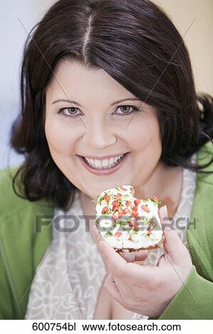 headshot of overweight woman eating bread with cream cheese View Large Photo Image Stock Image - headshot of overweight woman eating bread with cream cheese. Fotosearch