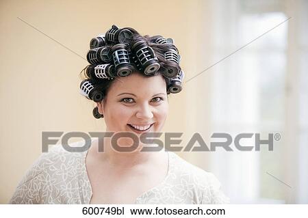 Stock Image - headshot of woman with curlers in her hair. Fotosearch