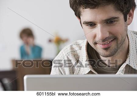 headshot of young man at home working on laptop computer View Large Photo Image Stock Image - headshot of young man at home working on laptop computer. Fotosearch