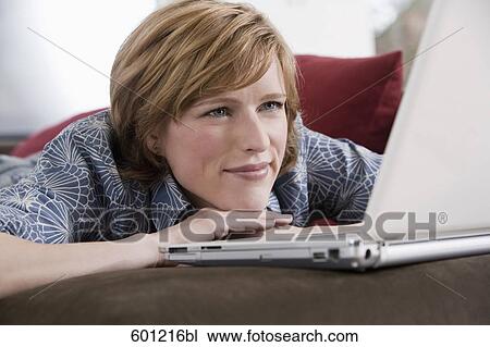 headshot of young woman at home working with laptop computer View Large Photo Image Stock Image - headshot of young woman at home working with laptop computer. Fotosearch