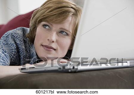 headshot of young woman at home working with laptop computer View Large Photo Image Stock Image - headshot of young woman at home working with laptop computer. Fotosearch