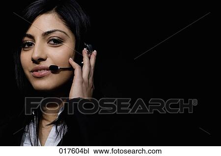 Stock Image - headshot of young woman wearing headset. Fotosearch