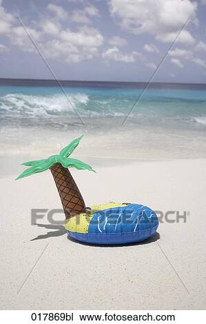 inflatable in shape of island with palm tree lying on sandy beach View Large Photo Image Stock Image - inflatable in shape of island with palm tree lying on sandy beach. Fotosearch