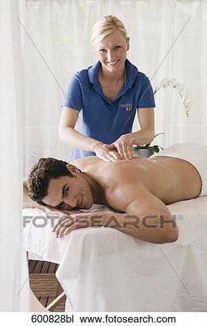 man lying on massage bench undergoing massage treatment View Large Photo Image Stock Image - man lying on massage bench undergoing massage treatment. Fotosearch