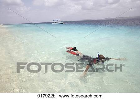 Stock Image - man snorkeling in tropical ocean. Fotosearch