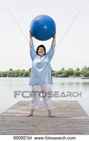 overweight woman doing exercises with blue ball on pier by lake View Large Photo Image Stock Image - overweight woman doing exercises with blue ball on pier by lake. Fotosearch