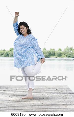 overweight woman doing stretching exercises on pier by lake View Large Photo Image Stock Image - overweight woman doing stretching exercises on pier by lake. Fotosearch