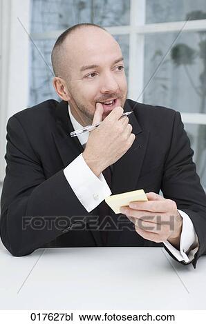 Stock Image - portrait of businessman holding post-its. Fotosearch
