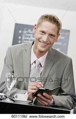 portrait of businessman in restaurant writing in his diary View Large Photo Image Stock Image - portrait of businessman in restaurant writing in his diary. Fotosearch