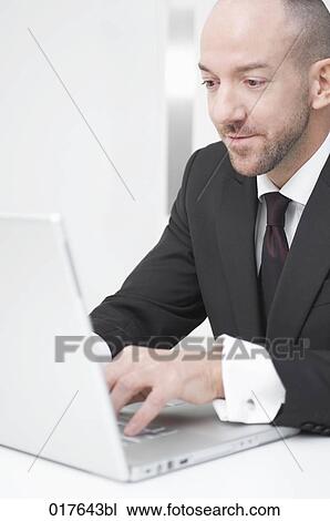 portrait of businessman writing on laptop computer View Large Photo Image Stock Image - portrait of businessman writing on laptop computer. Fotosearch