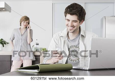 portrait of man working from home with woman talking on telephone View Large Photo Image Stock Image - portrait of man working from home with woman talking on telephone. Fotosearch