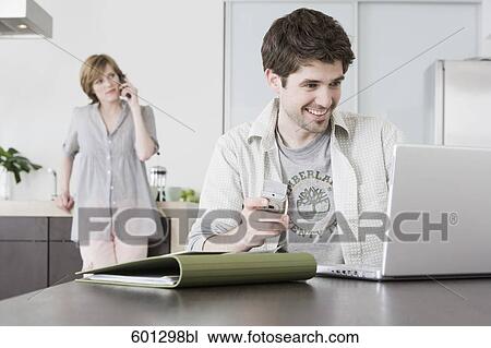 portrait of man working from home with woman talking on telephone View Large Photo Image Stock Image - portrait of man working from home with woman talking on telephone. Fotosearch