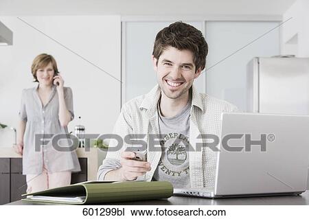 portrait of man working from home with woman talking on telephone View Large Photo Image Stock Image - portrait of man working from home with woman talking on telephone. Fotosearch