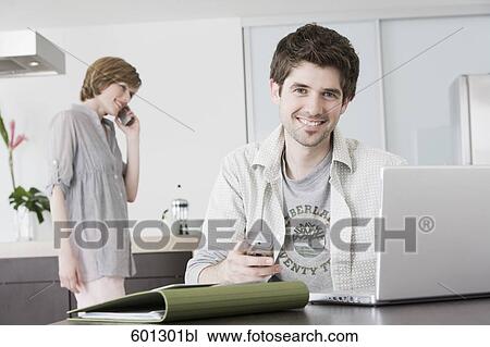 portrait of man working from home with woman talking on telephone View Large Photo Image Stock Image - portrait of man working from home with woman talking on telephone. Fotosearch
