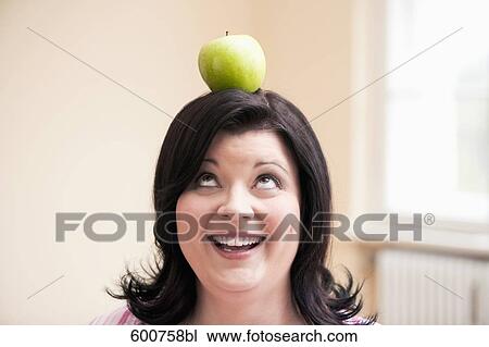 portrait of overweight woman balancing apple on her head View Large Photo Image Stock Image - portrait of overweight woman balancing apple on her head. Fotosearch