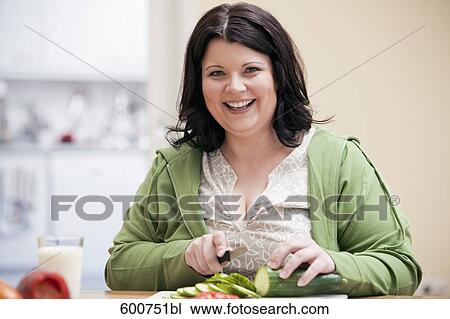 portrait of overweight woman in kitchen cutting cucumber View Large Photo Image Stock Image - portrait of overweight woman in kitchen cutting cucumber. Fotosearch