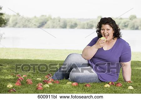 portrait of overweight woman in park eating apple View Large Photo Image Stock Image - portrait of overweight woman in park eating apple. Fotosearch