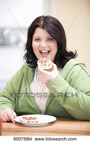 portrait of overweight woman sitting at table eating bread with cream cheese View Large Photo Image Stock Image - portrait of overweight woman sitting at table eating bread with cream cheese. Fotosearch