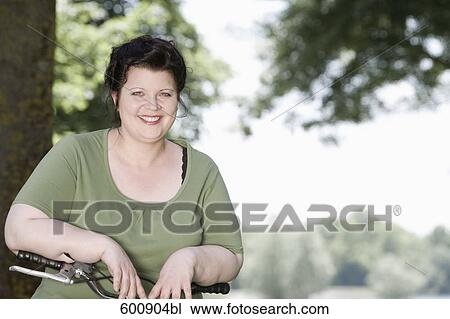 portrait of overweight woman with bicycle in park View Large Photo Image Stock Image - portrait of overweight woman with bicycle in park. Fotosearch
