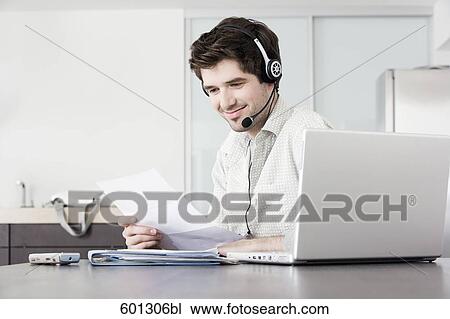 portrait of sitting at home working with computer and wearing headset View Large Photo Image Stock Image - portrait of sitting at home working with computer and wearing headset. Fotosearch