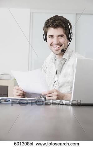 portrait of sitting at home working with computer and wearing headset View Large Photo Image Stock Image - portrait of sitting at home working with computer and wearing headset. Fotosearch