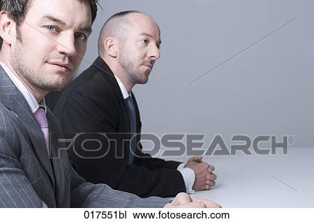portrait of two businessmen sitting at conference table View Large Photo Image Stock Image - portrait of two businessmen sitting at conference table. Fotosearch
