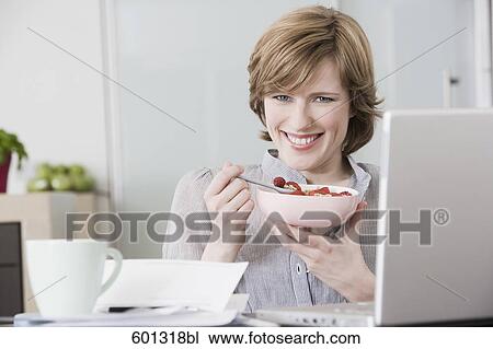 portrait of woman at home in front of computer eating snack View Large Photo Image Stock Image - portrait of woman at home in front of computer eating snack. Fotosearch