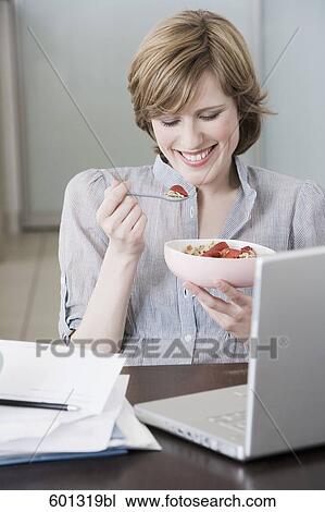 portrait of woman at home in front of computer eating snack View Large Photo Image Stock Image - portrait of woman at home in front of computer eating snack. Fotosearch
