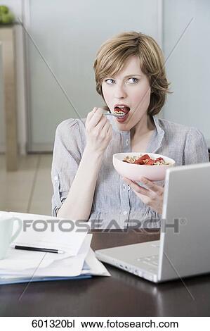portrait of woman at home in front of computer eating snack View Large Photo Image Stock Image - portrait of woman at home in front of computer eating snack. Fotosearch