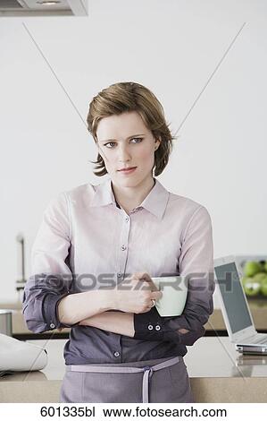 portrait of woman standing in kitchen holding coffee cup View Large Photo Image Stock Image - portrait of woman standing in kitchen holding coffee cup. Fotosearch