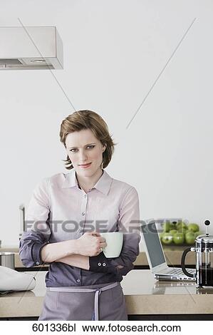 portrait of woman standing in kitchen holding coffee cup View Large Photo Image Stock Image - portrait of woman standing in kitchen holding coffee cup. Fotosearch